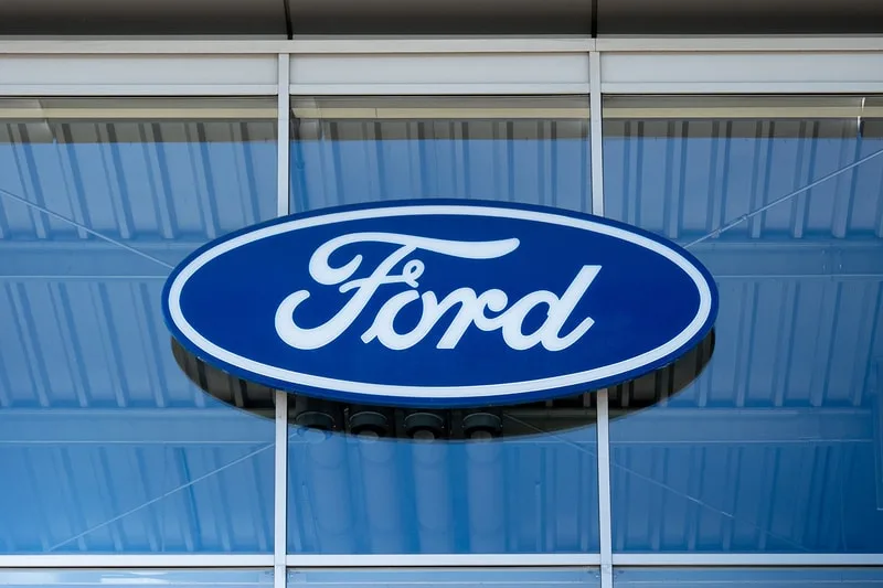 Logo bleu et blanc de Ford sur une façade en verre.
