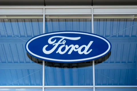 Logo bleu et blanc de Ford sur une façade en verre.