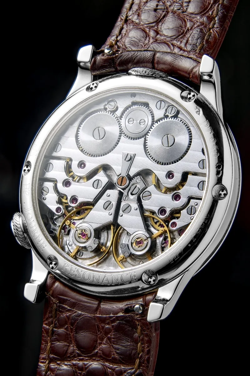 Dos d'une montre mécanique avec mécanisme complexe visible.