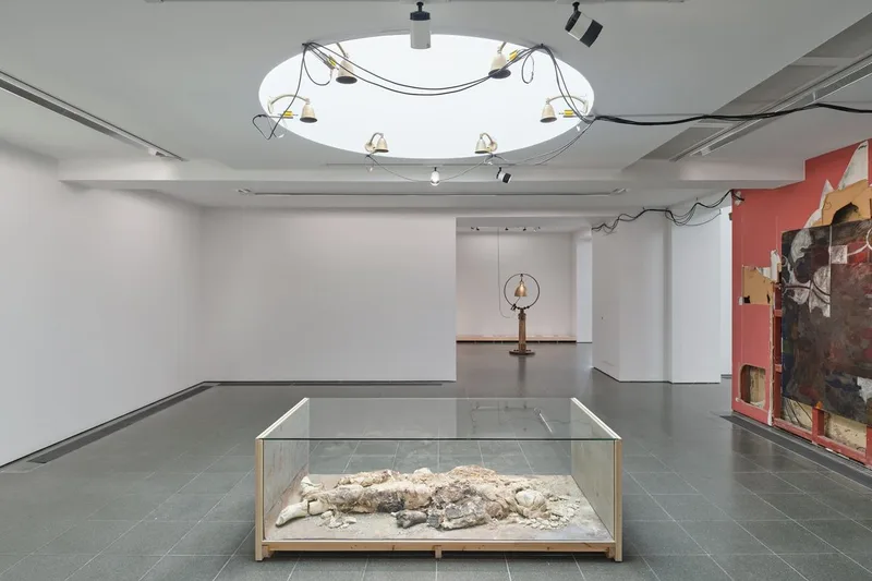 Installation artistique avec sculptures et peintures dans une galerie lumineuse.