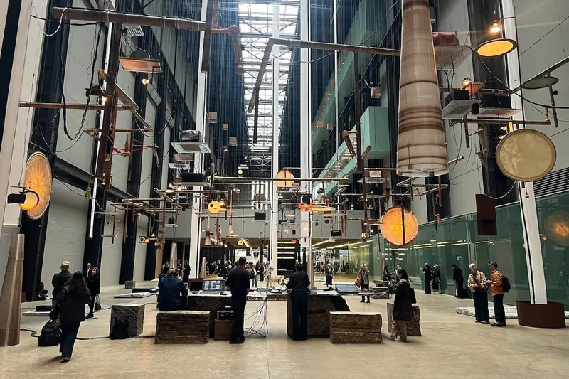 Installation artistique avec des objets suspendus au plafond, intérieur spacieux et moderne.