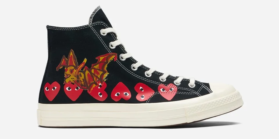 Chaussure montante noire avec cœurs rouges et motifs.