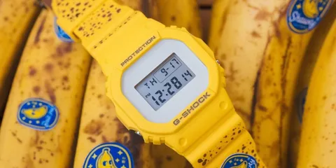 Montre jaune G-Shock sur des bananes jaunes tachetées d'autocollants bleus.