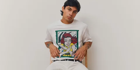 Homme assis portant un t-shirt avec illustration pop art.