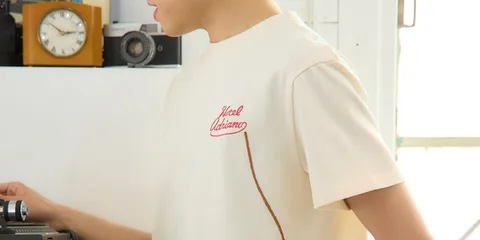 Personne en t-shirt "Hotel Okigama" beige.