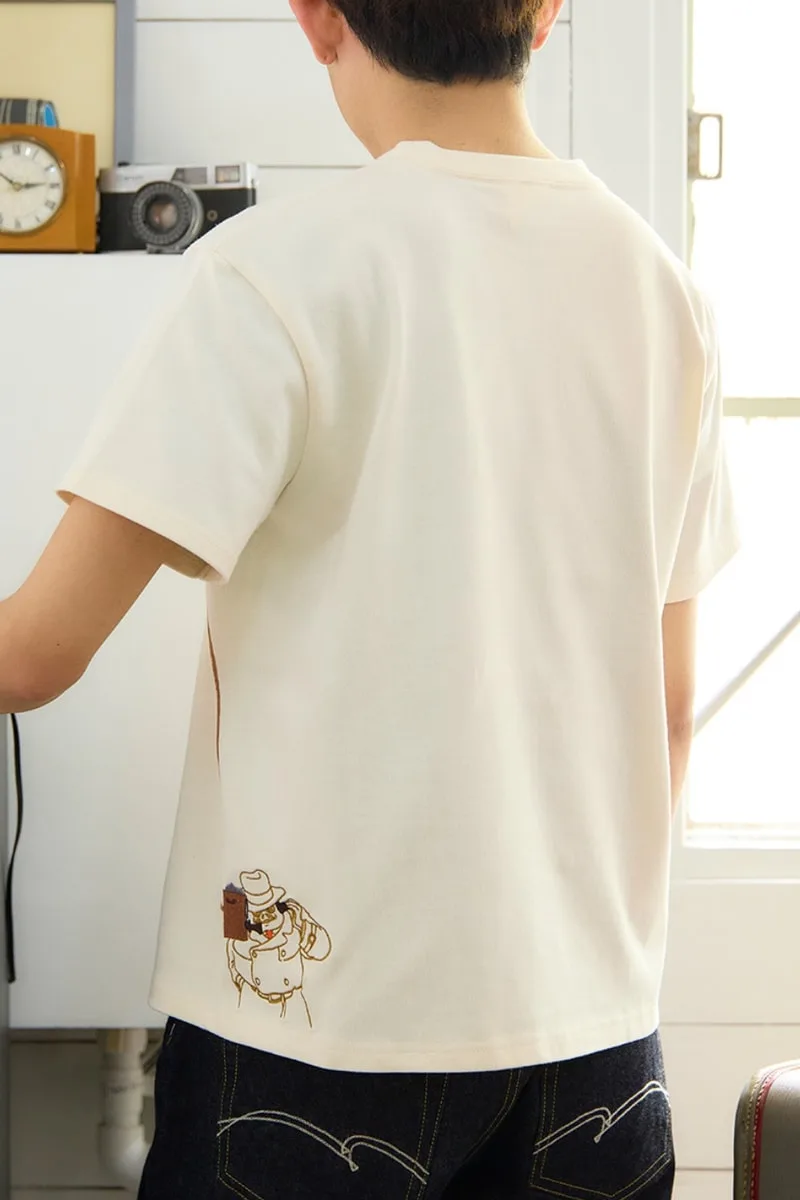 Homme en t-shirt avec dessin de robot, intérieur lumineux.
