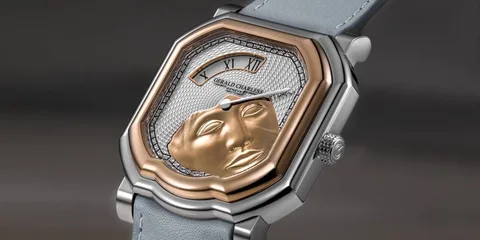 Montre avec cadran complexe et sculpture de visage doré.