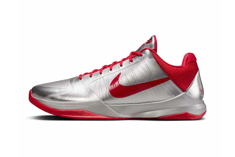 Chaussure de sport Nike avec design argent et rouge, logo Swoosh sur le côté.