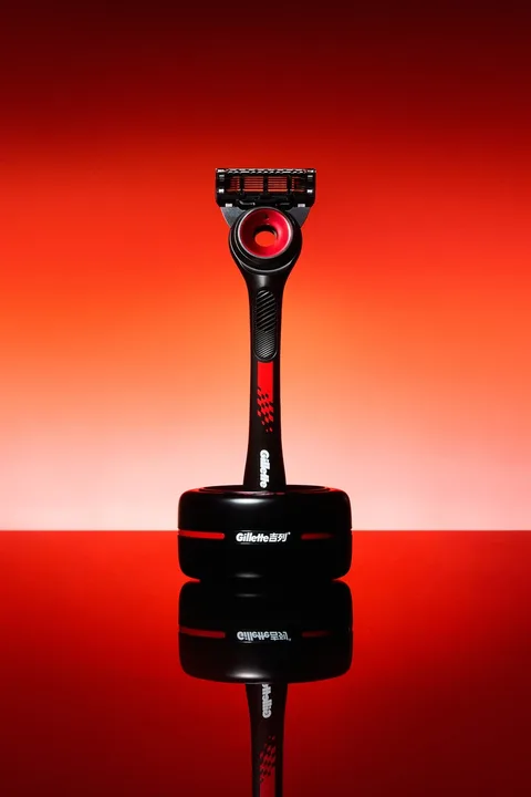 Rasoir noir et rouge sur fond rouge avec reflet.
