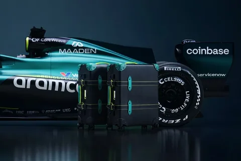 Voiture de course avec valises devant et logos sponsors visibles.