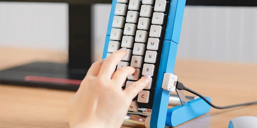 Clavier vertical bleu avec une main appuyant sur une touche