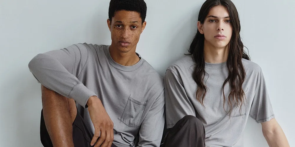 Deux personnes portant des t-shirts gris, assises côte à côte.