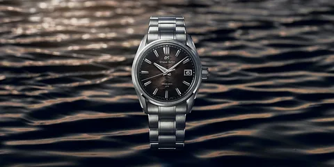 Montre en acier inoxydable sur fond de vagues d'eau.
