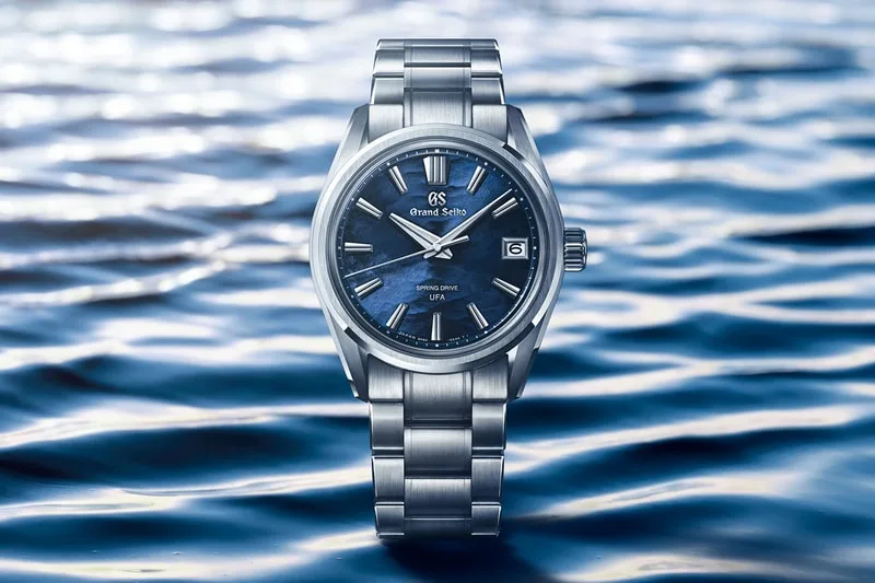 Une montre Grand Seiko sur fond de vagues bleues.