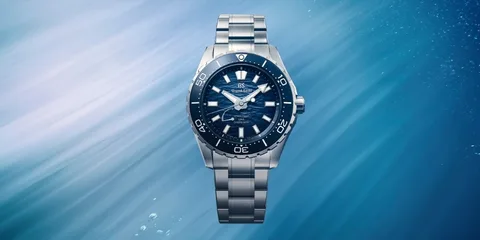 Montre-bracelet avec cadran bleu et bracelet en métal, sous l'eau.