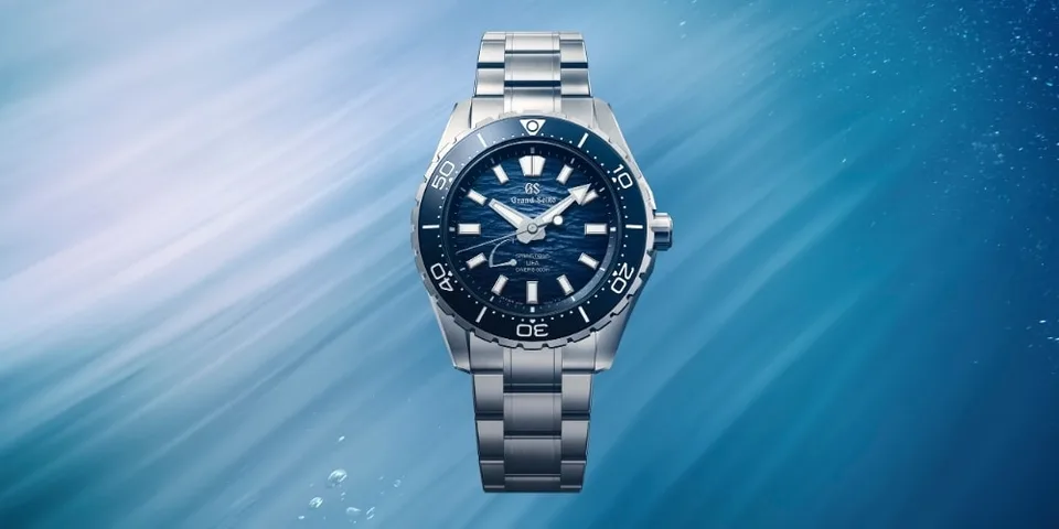 Montre-bracelet avec cadran bleu et bracelet en métal, sous l'eau.