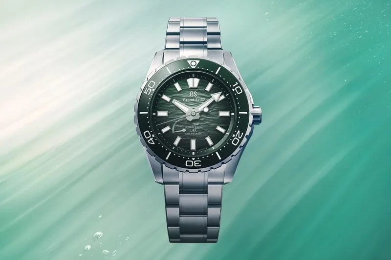 Montre argentée sur fond vert avec cadran texturé.