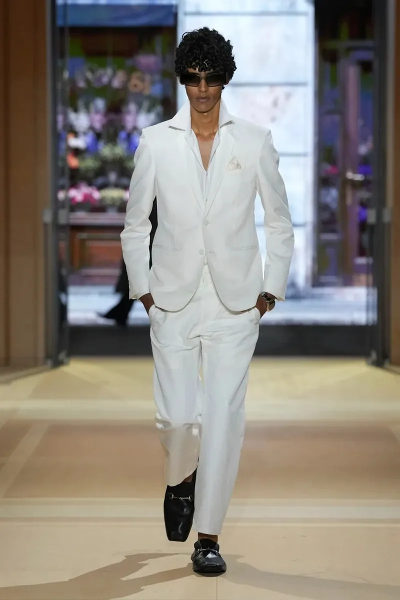 Homme en costume blanc et lunettes de soleil, défilé de mode.
