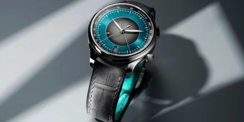 Montre avec cadran bleu et bracelet noir, éclairée en studio.