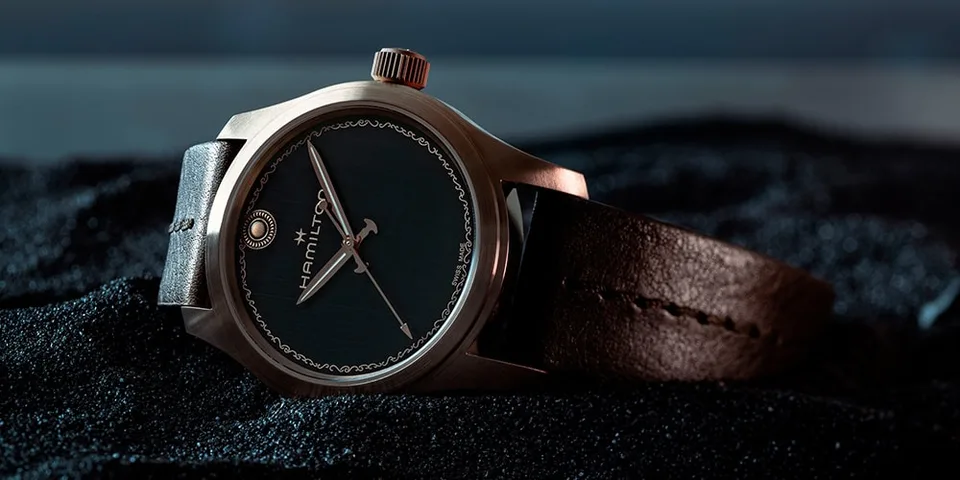 Montre-bracelet raffinée avec cadran sombre et bracelet en cuir.