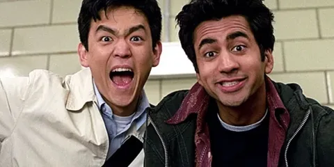 Deux hommes souriants dans un couloir.
