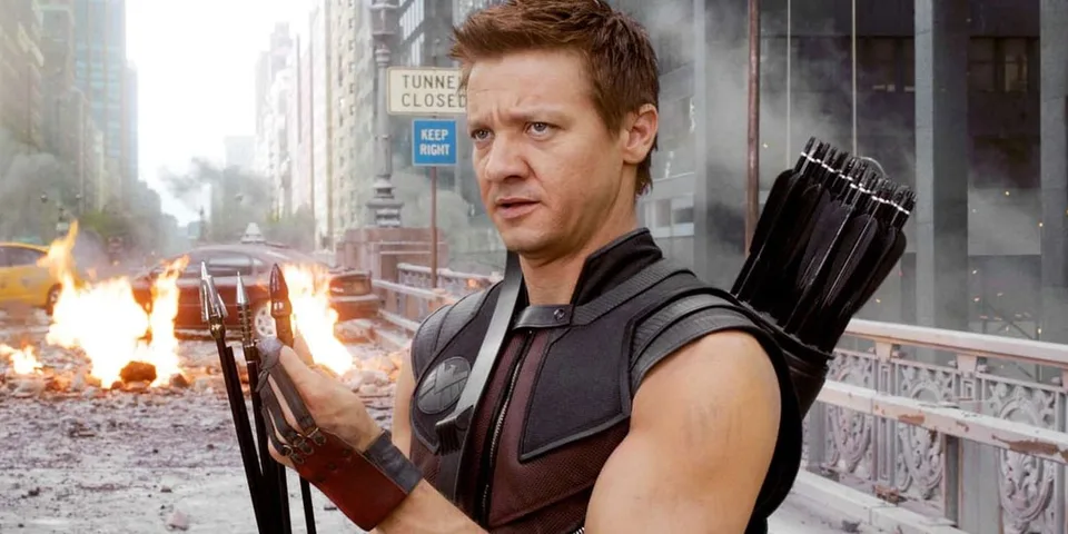 Personnage de film avec arc et flèches sur fond urbain en ruines.
