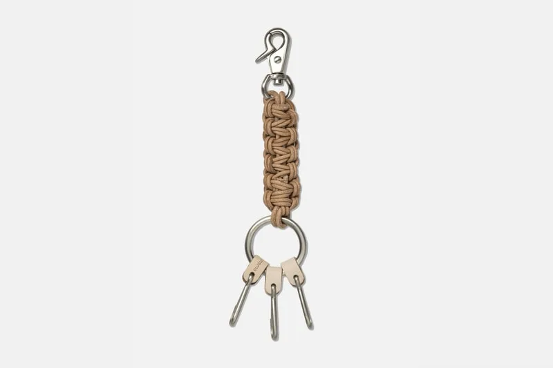 Porte-clés avec crochet et tressage en cuir beige.