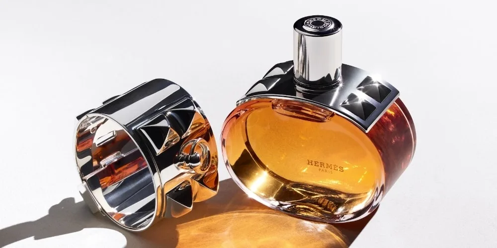 Bouteille de parfum Hermès avec bracelet argenté.