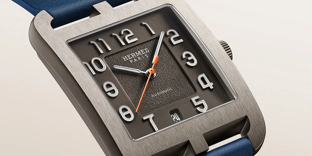 Montre Hermès avec cadran gris et bracelet bleu, chiffres blancs.