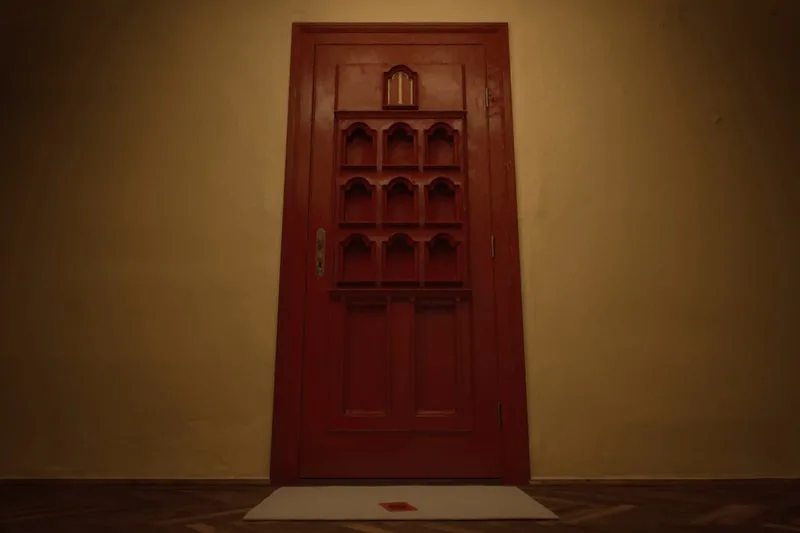Porte marron avec motifs rectangulaires sur un mur beige.