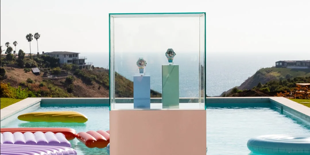 Deux montres exposées devant une piscine avec vue océan.