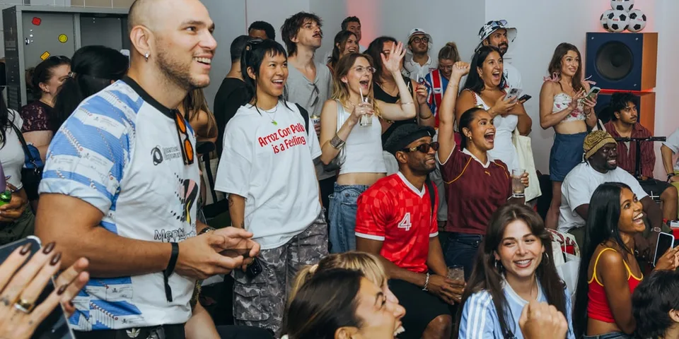 Groupe de personnes souriantes lors d'un événement social intérieur, applaudissant.