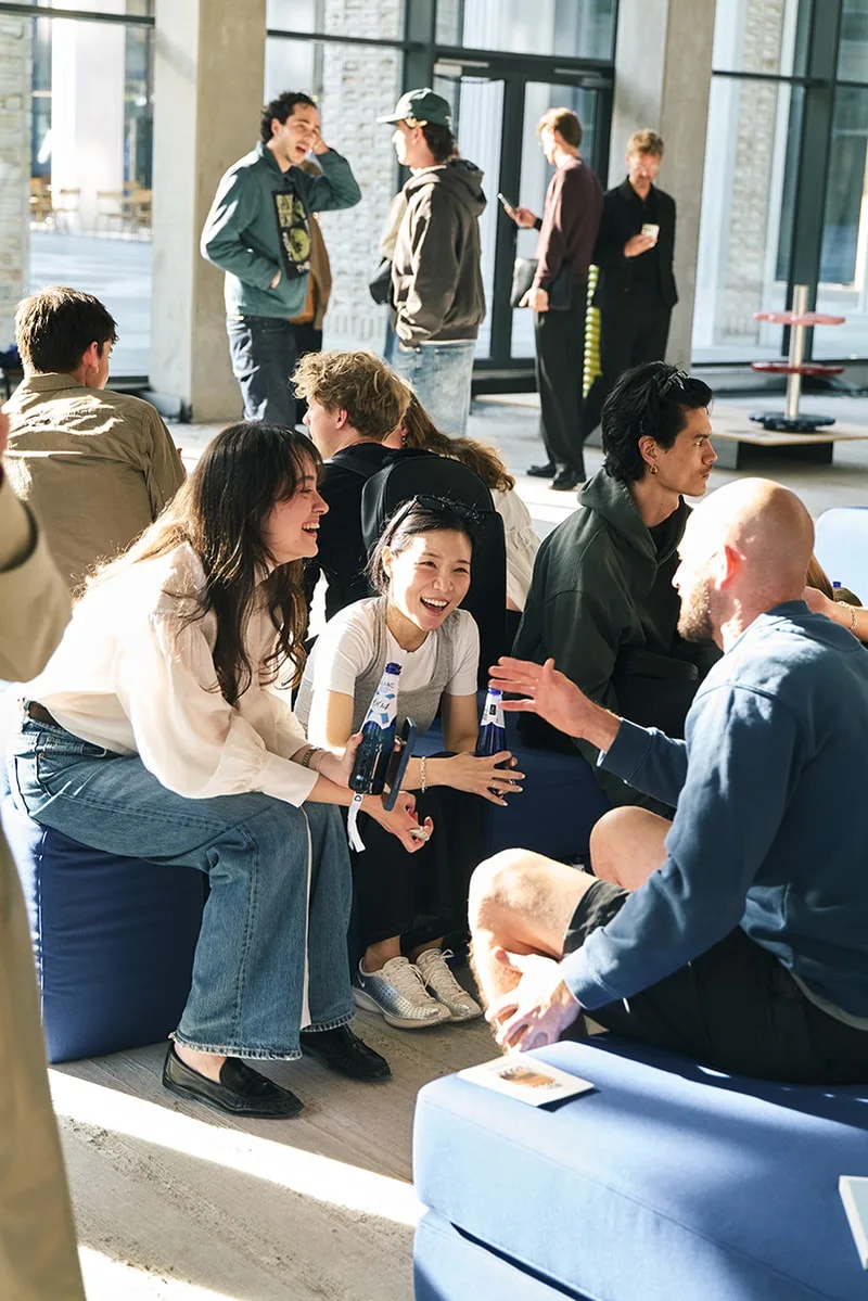 Groupe de personnes discutant joyeusement dans un espace lumineux.