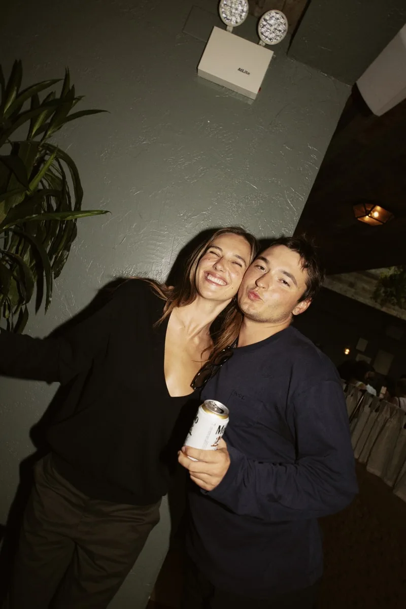Deux personnes souriantes posant ensemble avec une boisson.