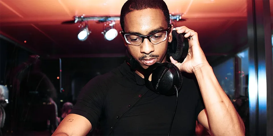 Homme avec casque de DJ, lunettes, éclairage rouge.