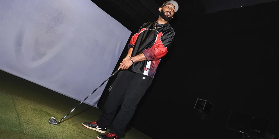 Homme avec club de golf dans un simulateur intérieur.