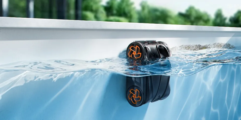 Robot nettoyeur de piscine autonome flottant à la surface de l'eau.