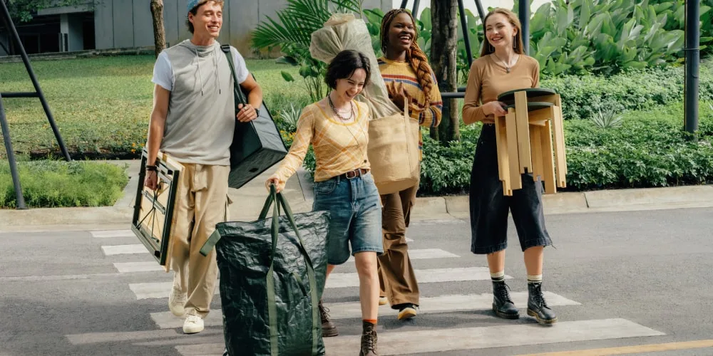 Quatre personnes traversant la rue avec des meubles.