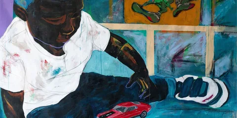 Enfant jouant avec une petite voiture rouge devant une fresque colorée.