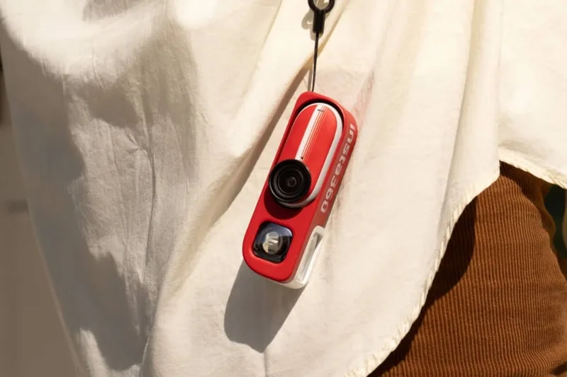 Caméra portable rouge accrochée à un vêtement.
