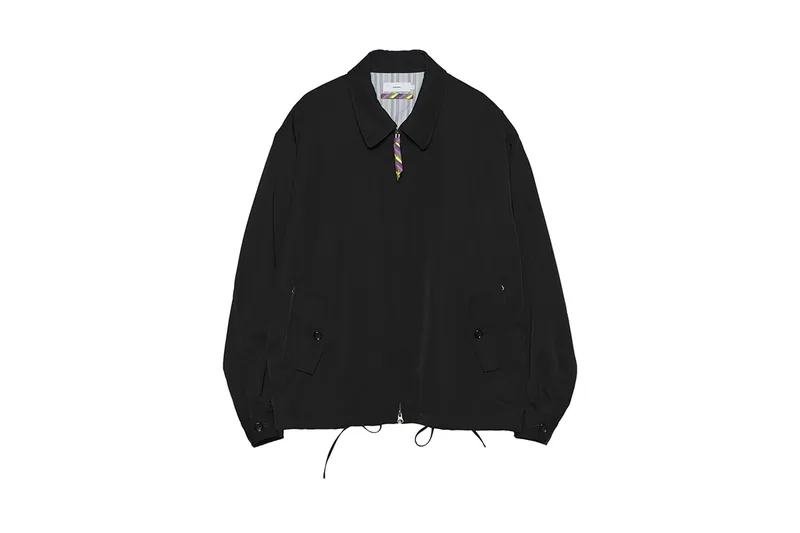 Blouson noir avec col replié et zip frontal.