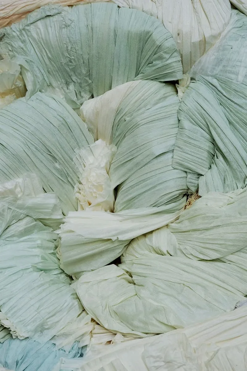 Piles de tissus verts et blancs plissés.