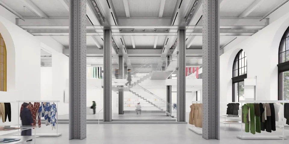 Intérieur moderne avec piliers, vêtements sur présentoirs.