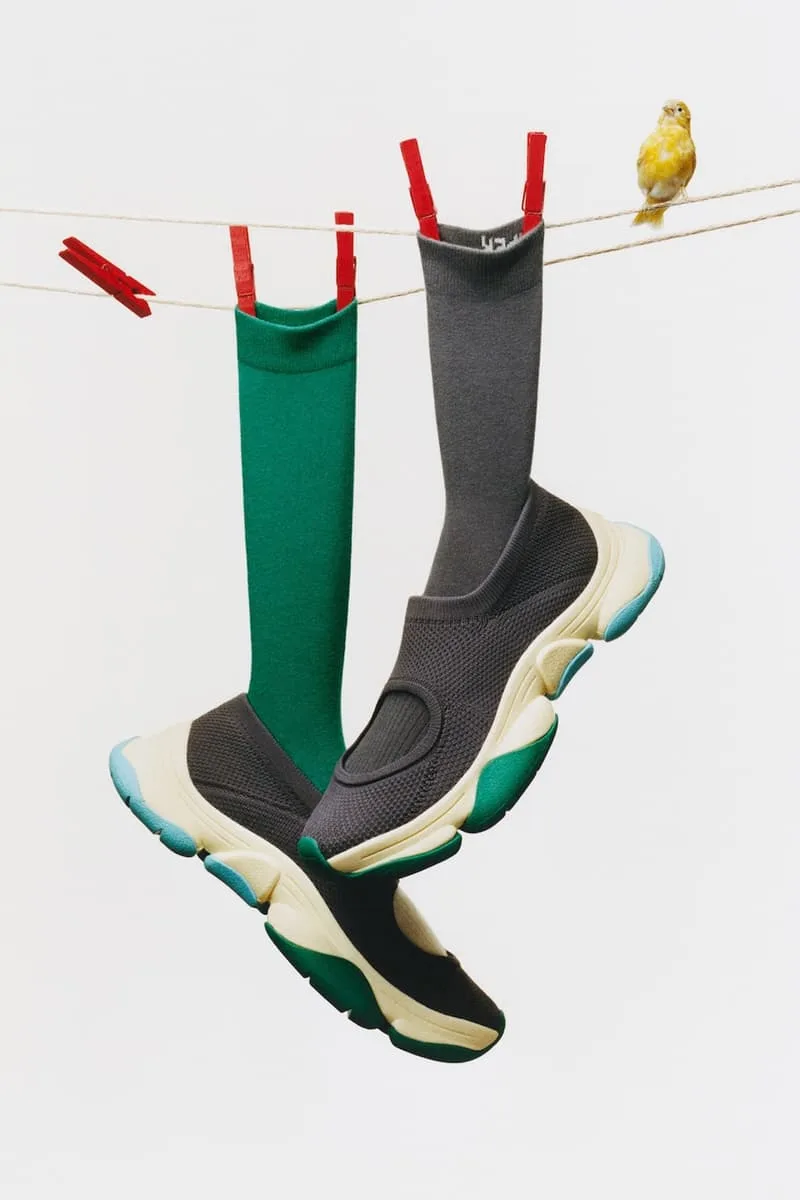 Chaussures noires avec chaussettes suspendues sur une corde et oiseau jaune.
