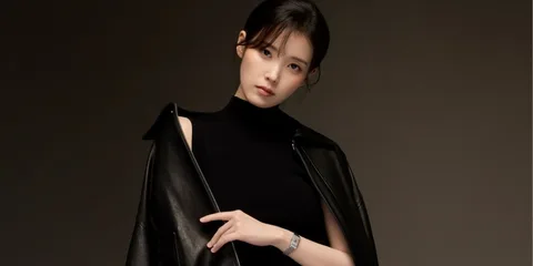 Femme vêtue de noir et portant un blouson en cuir noir.