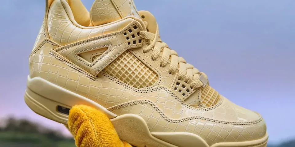 Basket jaune texturée avec motif croco, tenue par un gant jaune