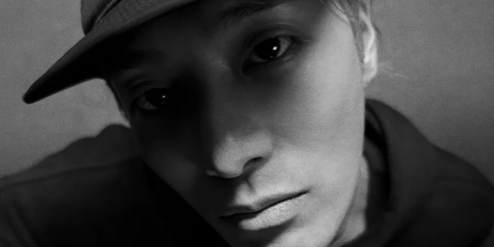 Portrait artistique en noir et blanc d'une personne portant une casquette.