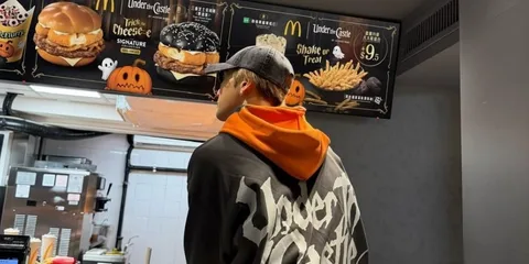 Personne en sweat Under Castle au comptoir McDonald's décoré pour Halloween.