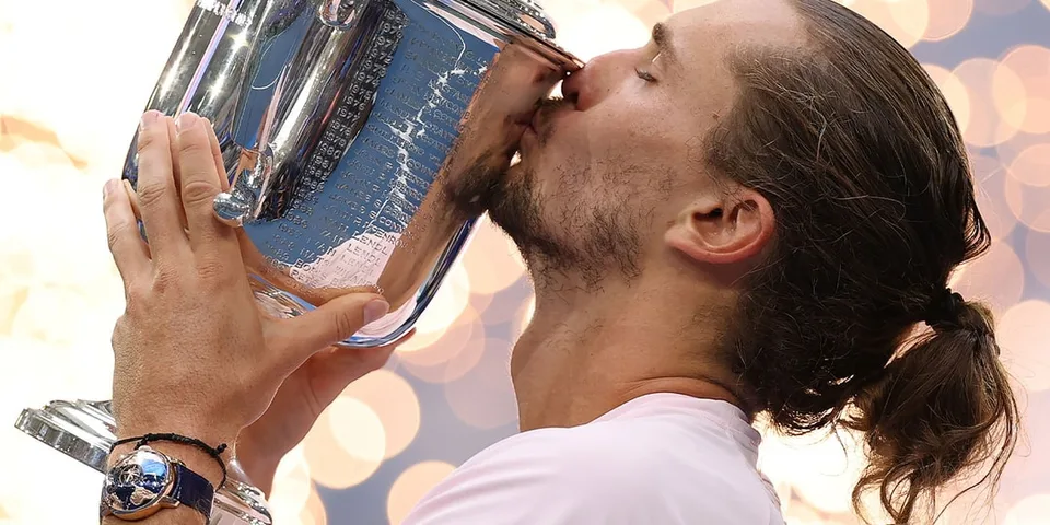 Joueur de tennis embrassant un trophée argenté avec fond lumineux.