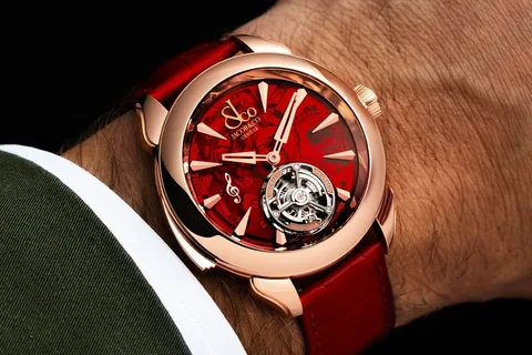 Montre-bracelet rouge et or avec un cadran complexe.